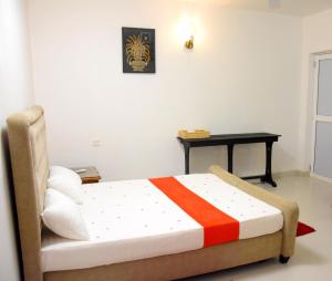 Cama en habitación con mesa y cama sidx sidx sidx sidx en Ranathisara Grand Hotel en Kurunegala