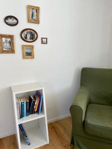 a living room with a green couch and a book shelf at Gemütliches Haus mit Seeblick in Ermatingen
