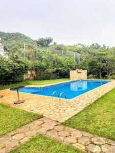 una piscina en una zona de césped con en Chácara (Condomínio Portal dos Nobres- Atibaia/SP), en Atibaia