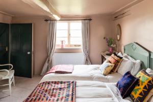 a bedroom with two beds and a window at Apple Cottage - Vivre Retreats in Wimborne Minster