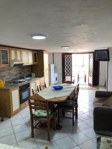 a kitchen with a table and some chairs and a kitchen with a table at Milicia Apartment in Mandra Capreria