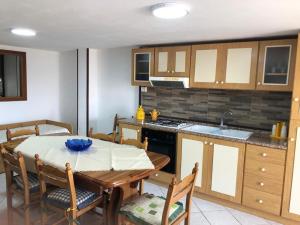 a kitchen with a table and a dining room at Milicia Apartment in Mandra Capreria