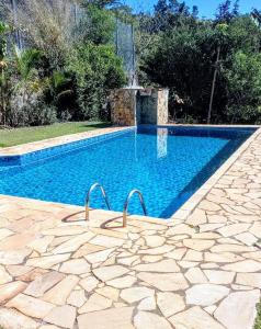 einen Pool in einem Hof mit einem Steingang daneben in der Unterkunft Chácara (Condomínio Portal dos Nobres- Atibaia/SP) in Atibaia