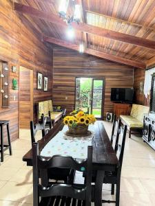 ein Esszimmer mit einem Tisch und einem Korb mit Sonnenblumen in der Unterkunft Chácara (Condomínio Portal dos Nobres- Atibaia/SP) in Atibaia