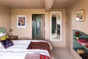 a bedroom with a bed and a mirror at Apple Cottage - Vivre Retreats in Wimborne Minster