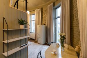 a dining room with a table and a refrigerator at Apart hotel на Франка by Willox in Chernivtsi