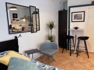 - un salon avec deux chaises et un miroir dans l'établissement Studio Le City - Petit déjeuner inclus 1ère nuit - AUX 4 LOGIS, à Foix
