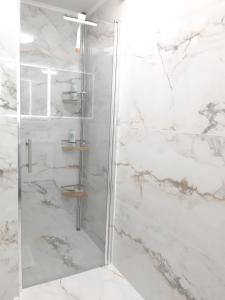 La salle de bains est pourvue d'une douche en marbre blanc. dans l'établissement Via Spalato Apartment, à Split
