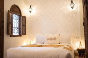 Riad IMPERIA في مراكش: غرفة نوم بسرير ابيض مع نافذة