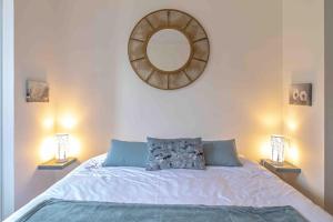a bedroom with a bed with a mirror on the wall at La Petite Chouette, charmant et cosy T2 in Dijon