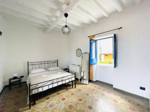 1 dormitorio con cama y ventana en Villa Margherita - Appartamenti a due passi dal corso di Santa Marina Salina a 100 mt dalla spiaggia, en Santa Marina Salina
