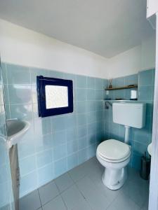 Baño azul con aseo y lavamanos en Villa Margherita - Appartamenti a due passi dal corso di Santa Marina Salina a 100 mt dalla spiaggia, en Santa Marina Salina