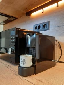 - une tasse de café assise devant un four micro-ondes dans l'établissement Via Spalato Apartment, à Split
