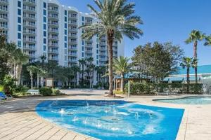 a pool with palm trees and a large building at Palms of Destin 21211 in Destin