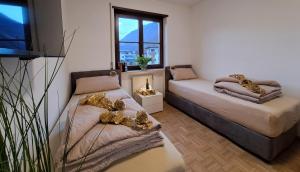 a bedroom with two beds and a window at Penthouse&Wellness L'Abete in Gargazzone