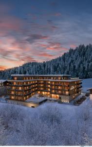 キルヒベルク・イン・チロルにあるAlpenParks Hotel & Apartment Taxacherの雪の中の建物の描写