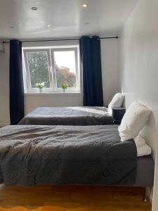 2 Betten in einem Schlafzimmer mit Fenster in der Unterkunft Fin uthyrningsdel med egen terass in Kungsängen