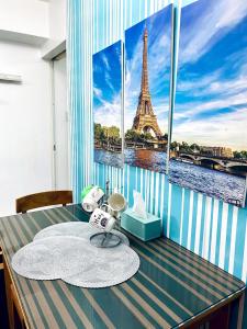 Cette chambre dispose d'une table et offre une vue sur la tour Eiffel. dans l'établissement Azure staycation by C&N, à Manille