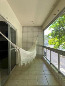 a room with a hammock hanging from the wall at Aconchegante 2Q em frente a praia Ponta da Fruta in Ponta da Fruta