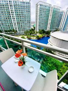 a white table with flowers on a balcony with buildings at Azure staycation by C&N in Manila