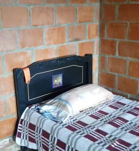La CumbreにあるFinca Villa Lailaのレンガの壁のドミトリールームのベッド1台分です。