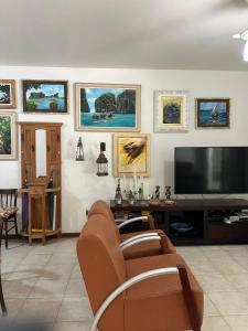 a living room with a couch and a flat screen tv at Aconchegante 2Q em frente a praia Ponta da Fruta in Ponta da Fruta