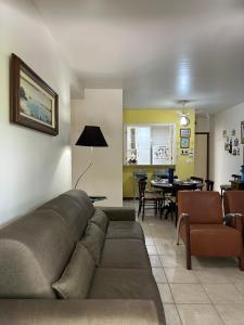 a living room with a couch and a dining room at Aconchegante 2Q em frente a praia Ponta da Fruta in Ponta da Fruta