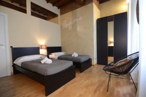 een slaapkamer met 2 bedden en een stoel bij Palazzuolo 112 - Keys Of Italy in Florence