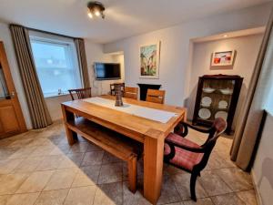 a dining room with a wooden table and chairs at Welcome to Fittie, on the beach! in Aberdeen