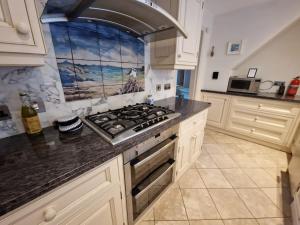 a kitchen with a stove top oven in a kitchen at Welcome to Fittie, on the beach! in Aberdeen