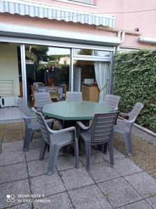 een groene tafel en stoelen op een patio bij Rez de jardin Pinède Proximité Quartier Naturiste in Cap d'Agde