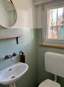 a bathroom with a white sink and a mirror at Gemütliches Haus mit Seeblick in Ermatingen