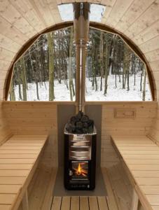 una sauna con chimenea frente a una ventana en Domek w lesie Sauna i Gorąca balia Wellness&Spa, en Grybów