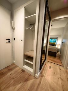 een kamer met een spiegel en een slaapkamer met een bed bij nord-ostseeglück in Ladelund