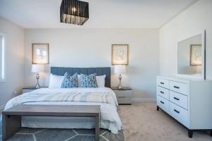 a bedroom with a bed and two lamps and a dresser at The Bliss in Bowmanville