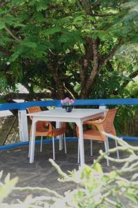 uma mesa branca com duas cadeiras e um vaso com flores em Diani Peaceful Garden em Diani Beach