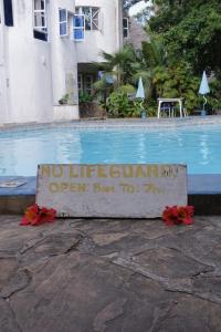 a no lifeguard sign next to a swimming pool at Diani Peaceful Garden in Diani Beach