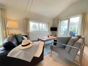uma sala de estar com um sofá e um chapéu sobre uma mesa em Watervilla de IJsvogel by Droomvilla em Langweer