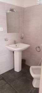 een badkamer met een witte wastafel en een toilet bij Kandy IVY Mountain View Resort in Kandy