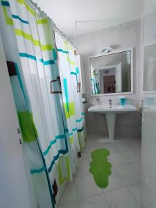 uma casa de banho com um lavatório e uma cortina de chuveiro em Spectacular Port View and Beach Apartment KANTAOUI SOUSSE em Port El Kantaoui