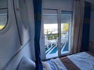 1 dormitorio con cama y vistas a un balcón en Spectacular Port View and Beach Apartment KANTAOUI SOUSSE en Port El Kantaoui