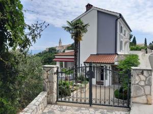 a gate with a palm tree in front of a house at Apartment in Vrbnik - Insel Krk 45252 in Vrbnik