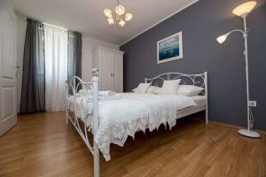a bedroom with a white bed and a blue wall at Apartment in Vrbnik - Insel Krk 45252 in Vrbnik