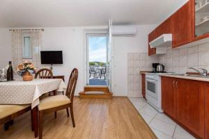 a kitchen and dining room with a table and a view at Apartment in Vrbnik - Insel Krk 45252 in Vrbnik