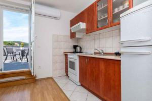 a kitchen with a white refrigerator and a balcony at Apartment in Vrbnik - Insel Krk 45252 in Vrbnik +27 photos