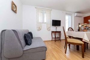 uma sala de estar com um sofá e uma sala de jantar em Apartment in Vrbnik - Insel Krk 45252 em Vrbnik