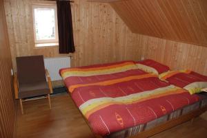 a bedroom with a bed and a chair and a window at Holiday home in Haj pod Klinovcem 1681 in Háj