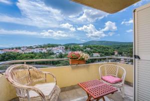 ein Balkon mit zwei Stühlen und einem Tisch in der Unterkunft Apartment in Vrbnik - Insel Krk 47401 in Vrbnik