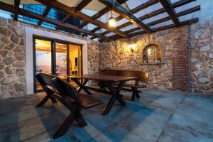 a wooden table and chairs in a room with a stone wall at Holiday home in Vrbnik - Insel Krk 45251 in Vrbnik
