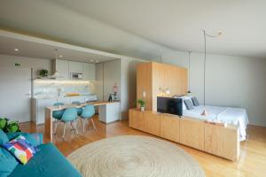 a living room with a bed and a kitchen with a couch at Baumhaus Serviced Living - Art & Design Apartments in Porto